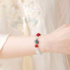 模特兒手腕佩戴懂飾鴻運硃砂手鍊,展現東方風格穿搭效果。